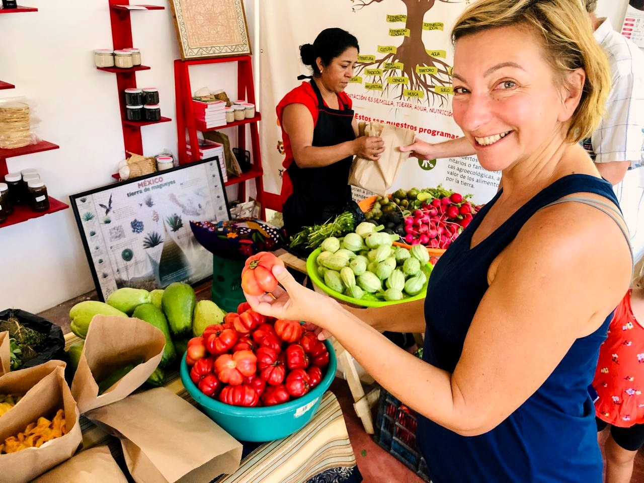 Guest choosing heirloom tomatoes at an agroecological market
