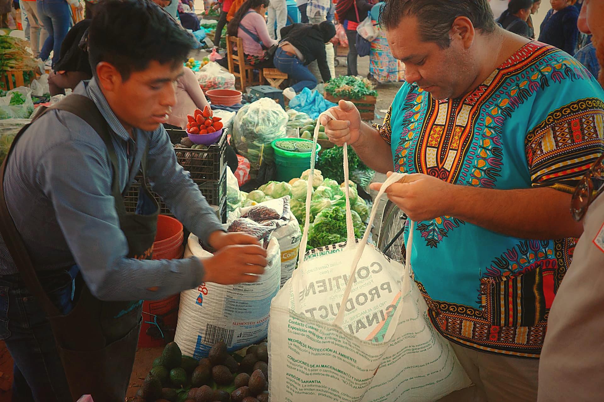 Chef Alfonso shopping at a local market with a producer, choosing fresh ingredients